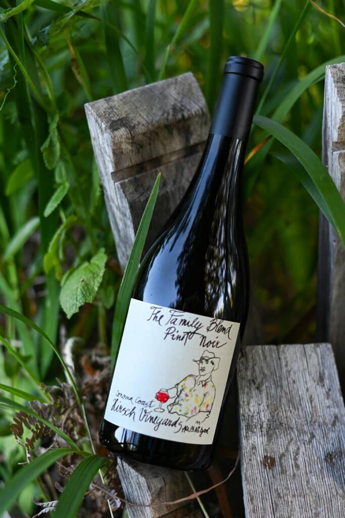 A bottle of Hirsch 'Family Blend' Estate Pinot Noir on barrel staves.
