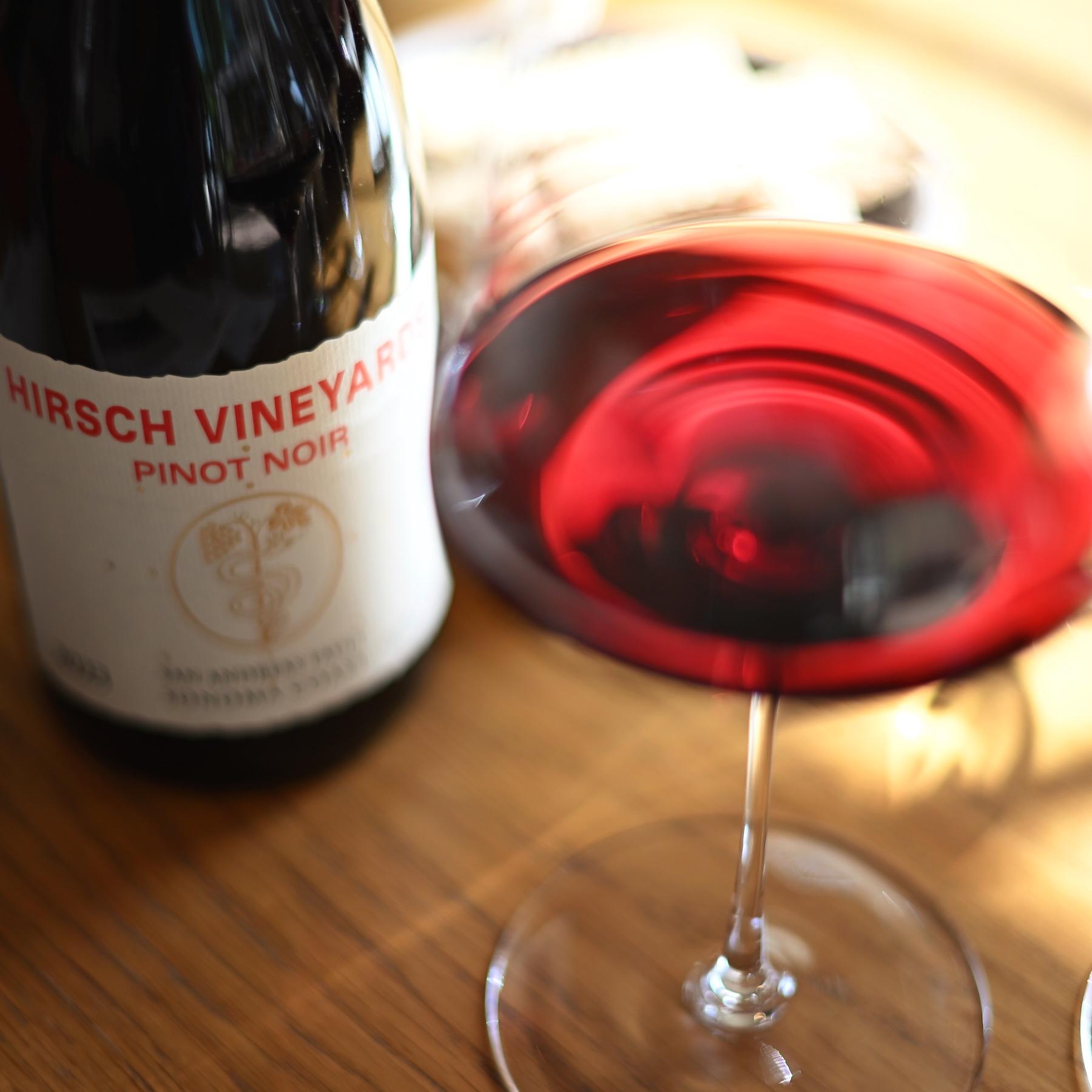 Hirsch Vineyards 'San Andreas Fault' Estate Pinot Noir wine bottle and wine glass with wine in it.